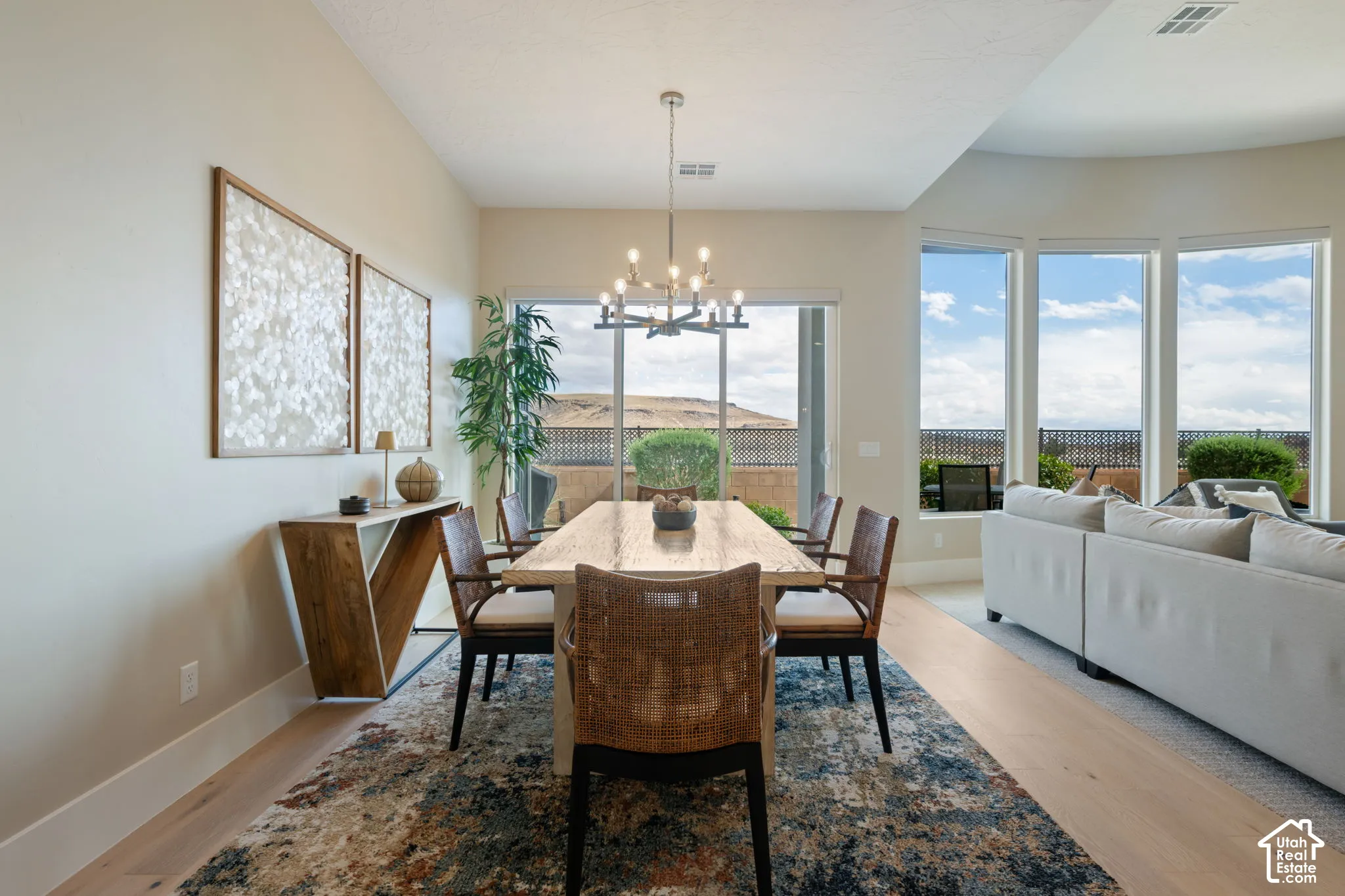 Dining area featuring light wood-finish flooring, a contemporary chandelier, and large sliding glass doors