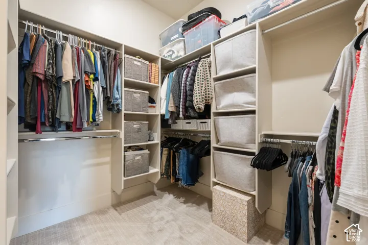 Walk-in closet featuring extensive built-in shelving, multiple hanging rods, and integrated storage compartments