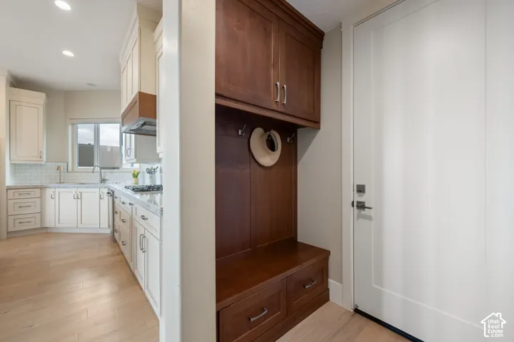 Built-in mudroom storage with bench seating and overhead cabinetry