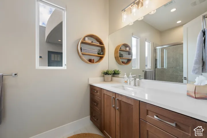 Expansive vanity with a white countertop and dual sinks, complemented by warm-toned cabinetry