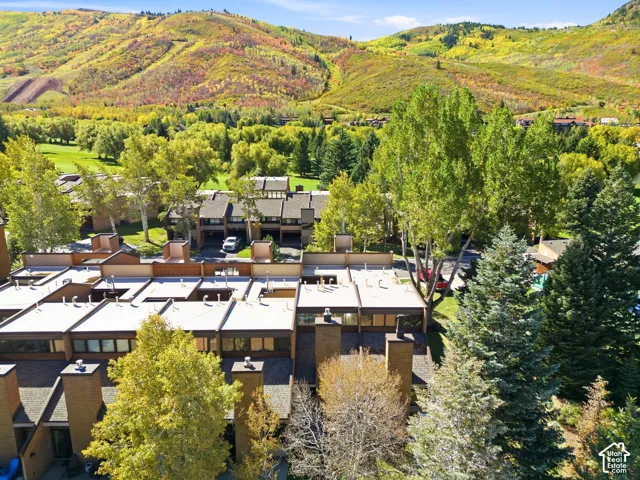 Townhome community featuring a brick and wood exterior, flat roofs, and mature landscaping