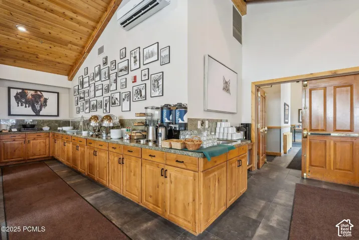 Wood-finish vaulted ceiling, extensive wood-finish cabinetry, stone-finish countertops, and durable flooring