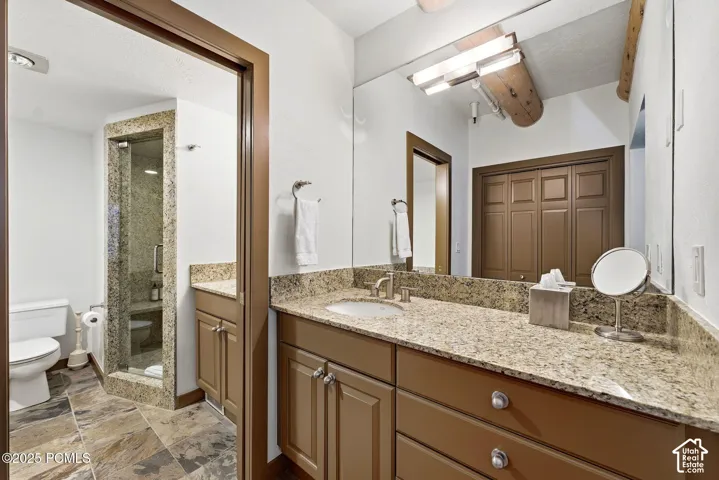 Vanity with integrated sink, stone countertop, and wood-finish cabinetry