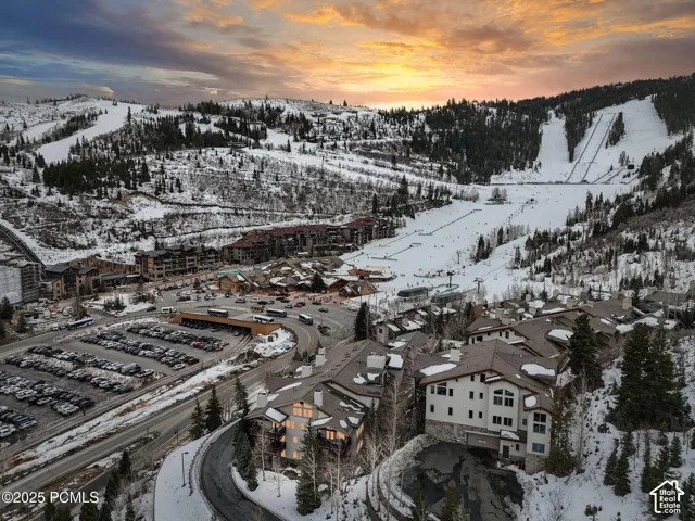 Snow-covered mountain landscape featuring multi-story residential structures and ski slopes