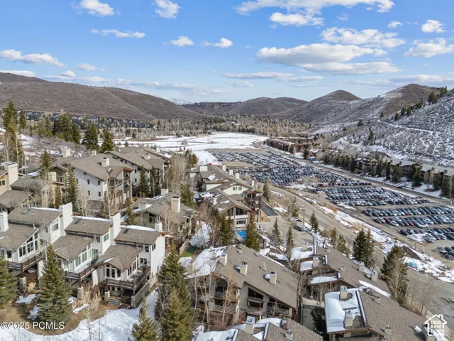 Multi-level structures with balconies, pitched roofs, and chimney features situated within a mountainous landscape