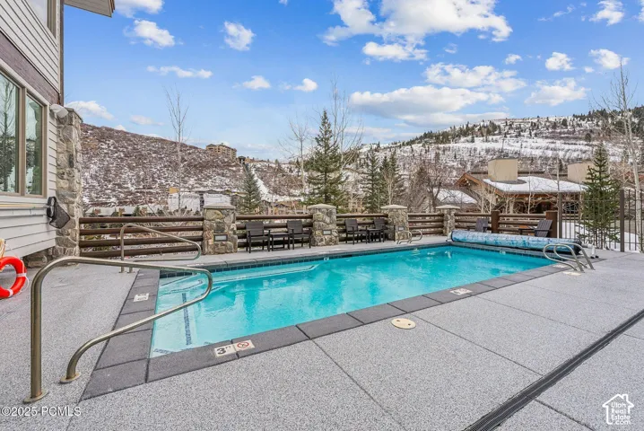 Outdoor pool with gray-toned surround and metal railings