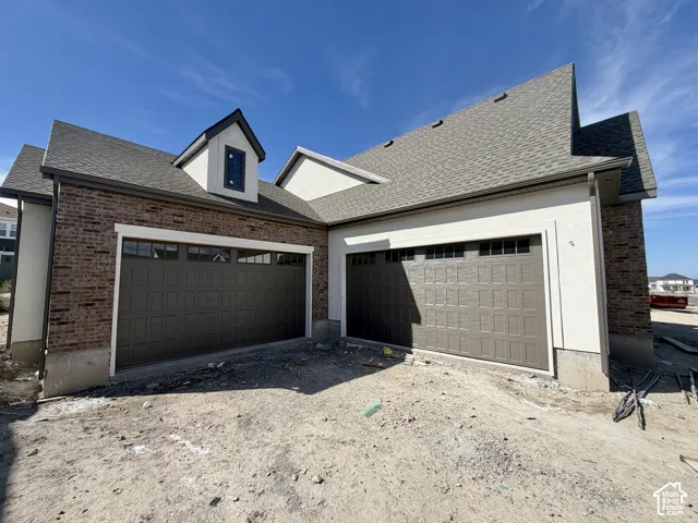Brown brick exterior with light-colored stucco accents