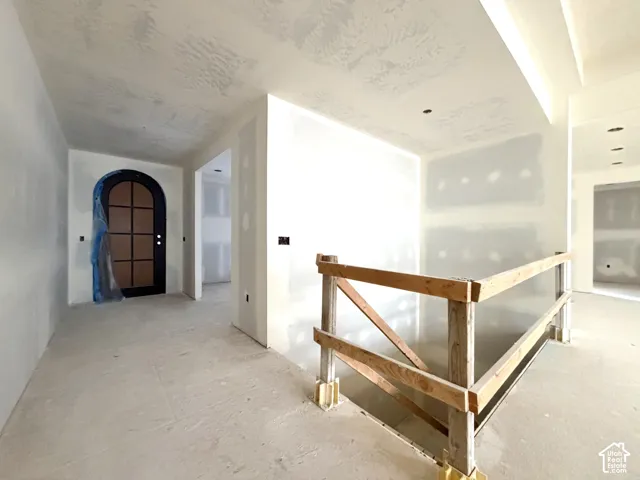 Arched entryway with a dark-framed door, recessed lighting, and smooth ceiling finishes