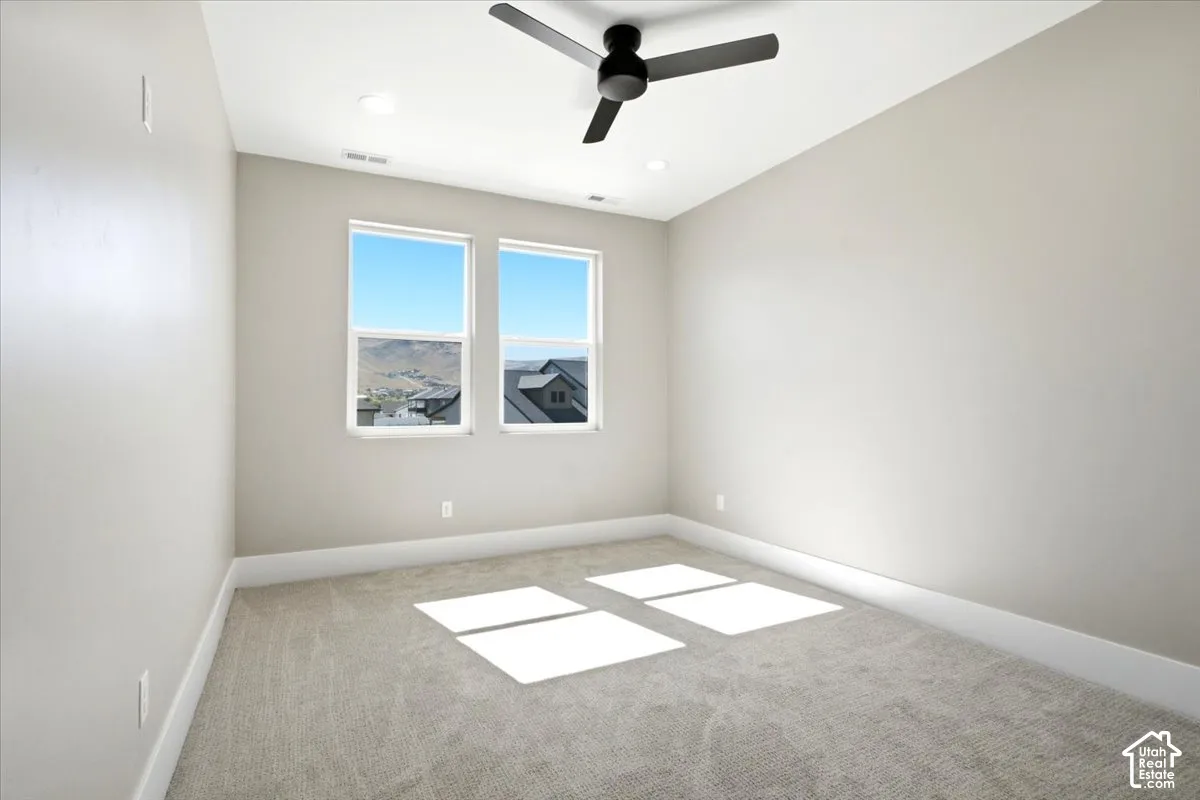 Neutral tone wall paint, light gray carpet, dual windows, ceiling fan, and recessed lighting