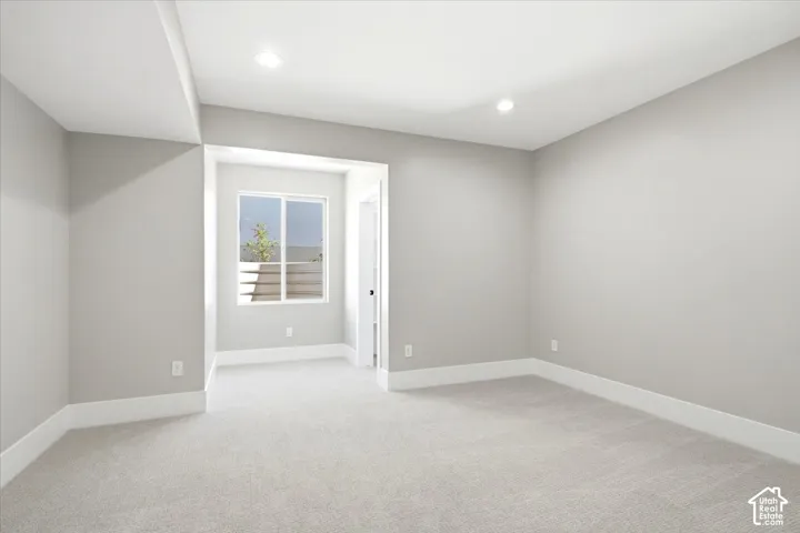 Recessed lighting, light gray wall finish, white baseboards, and a window with white trim