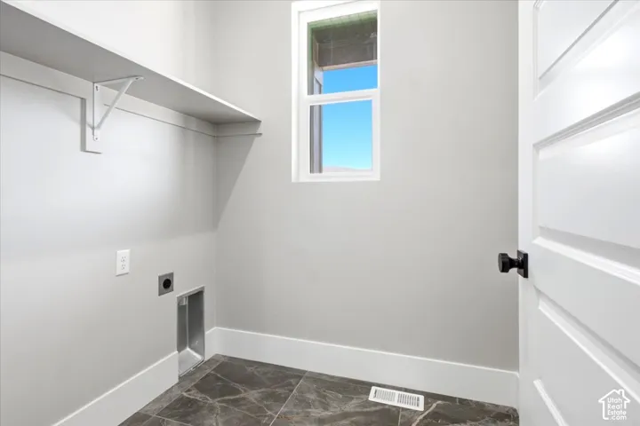 Built-in shelving, window for natural light, dark-toned flooring, white trim, and a panel door with dark hardware