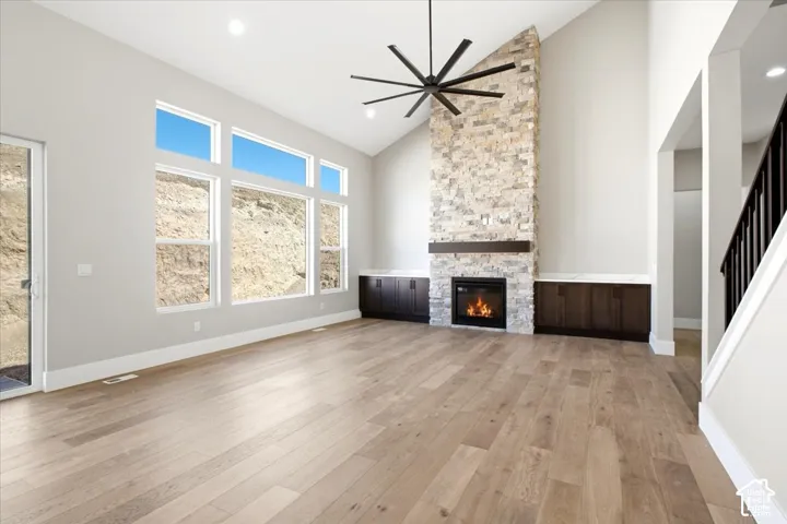 Vaulted ceilings with a prominent stone-clad fireplace and wood-finish mantel