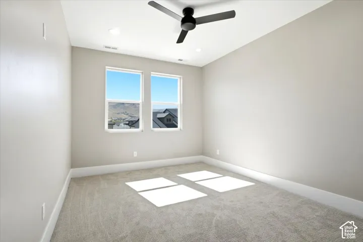 Neutral tone wall paint, light gray carpet, dual windows, ceiling fan, and recessed lighting