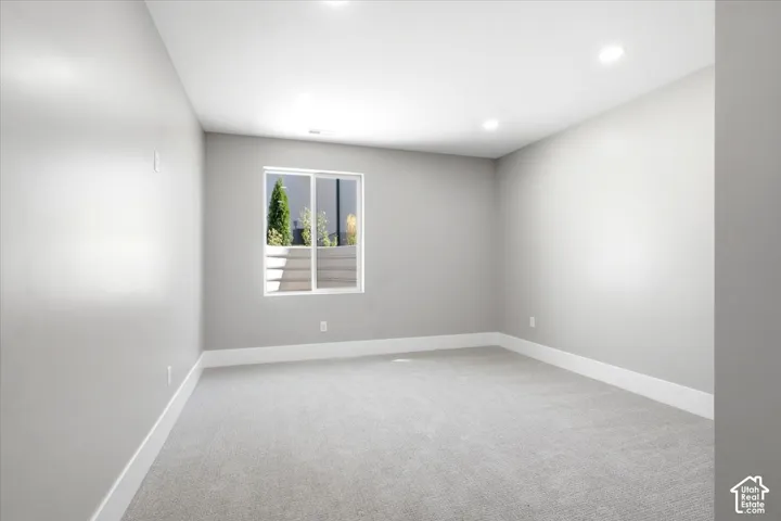 Recessed lighting, light gray walls, white trim, and light gray carpet
