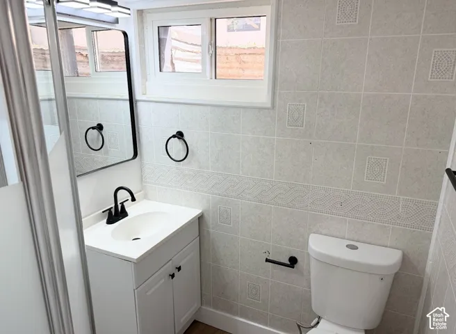 White vanity with black faucet, framed mirror, and integrated sink