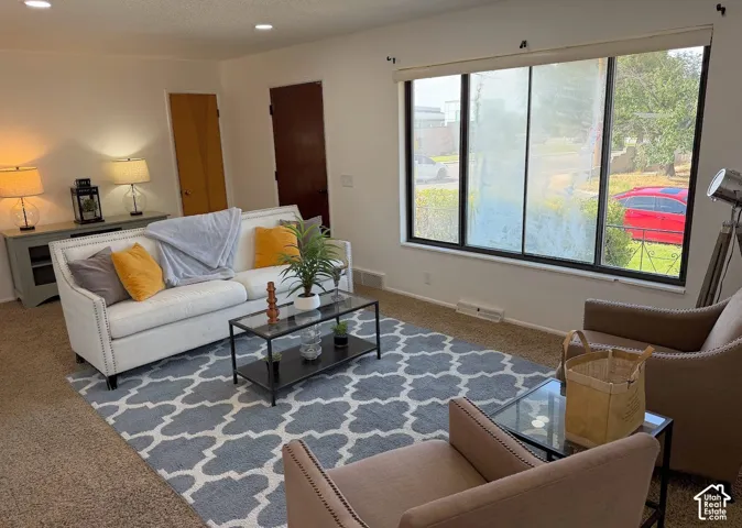 Living area featuring recessed lighting, a large picture window, and carpeted flooring