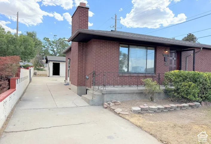 Brick exterior with an attached chimney and a front entry