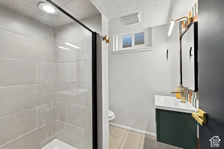 Walk-in shower with tiled surround and black-framed glass enclosure