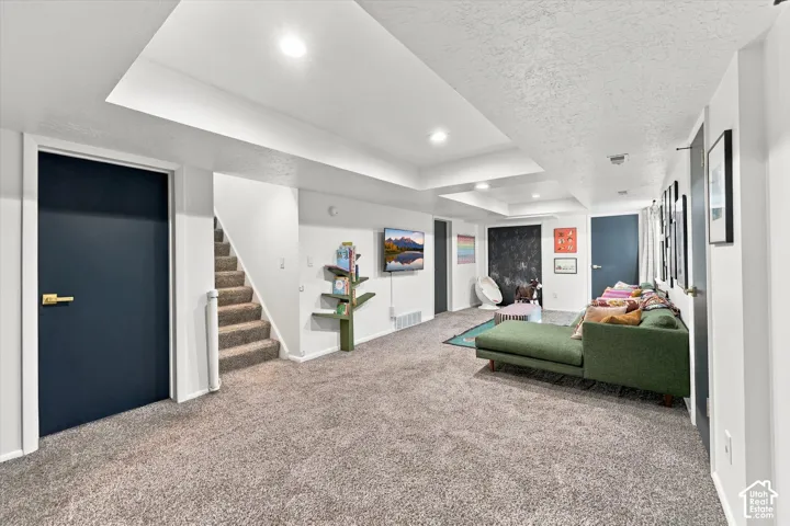 Carpeted flooring extending throughout, recessed lighting in ceiling, white walls, and dark-paneled doors