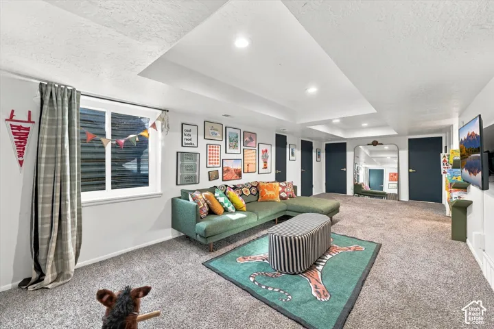 Recessed lighting throughout, plush carpet flooring, white window trim, and dark-paneled doors