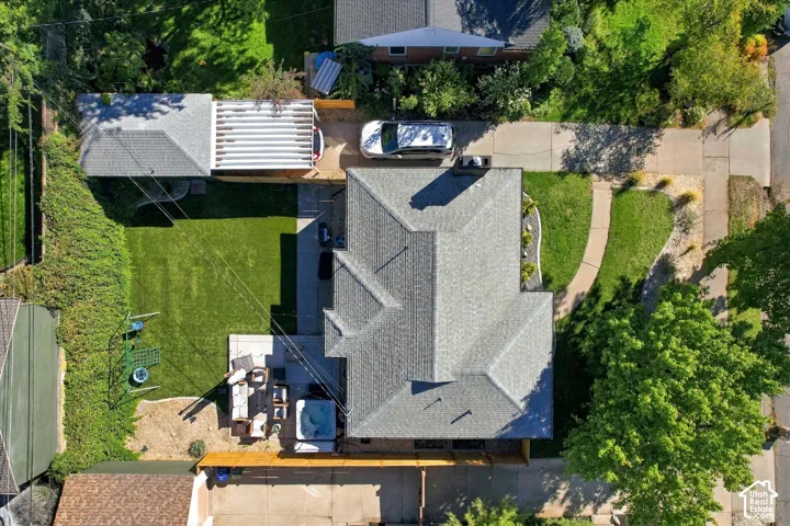 Expansive backyard featuring a manicured lawn, concrete patio, and built-in spa