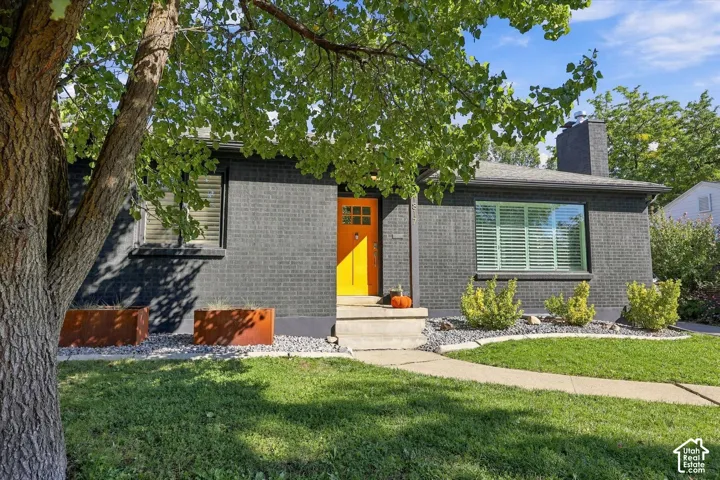 Black brick exterior with an yellow entry door