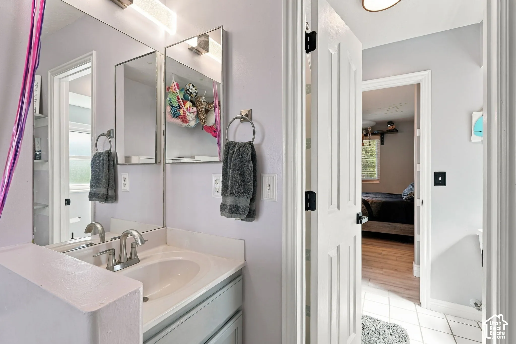 Integrated vanity with a single basin sink, brushed nickel faucet, and dual mirrored medicine cabinets