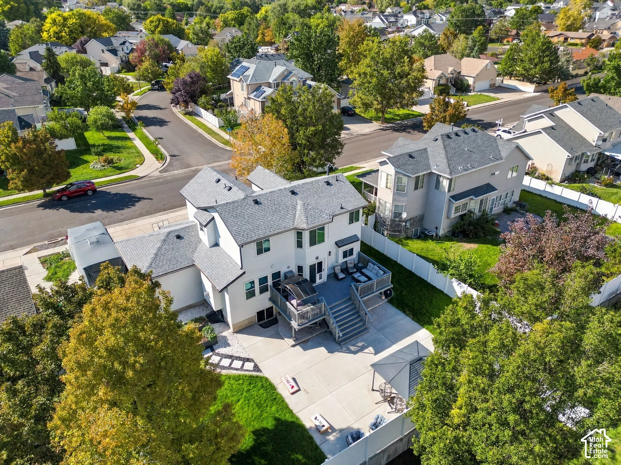 Expansive rear deck with multiple levels, concrete patio, and a grass lawn