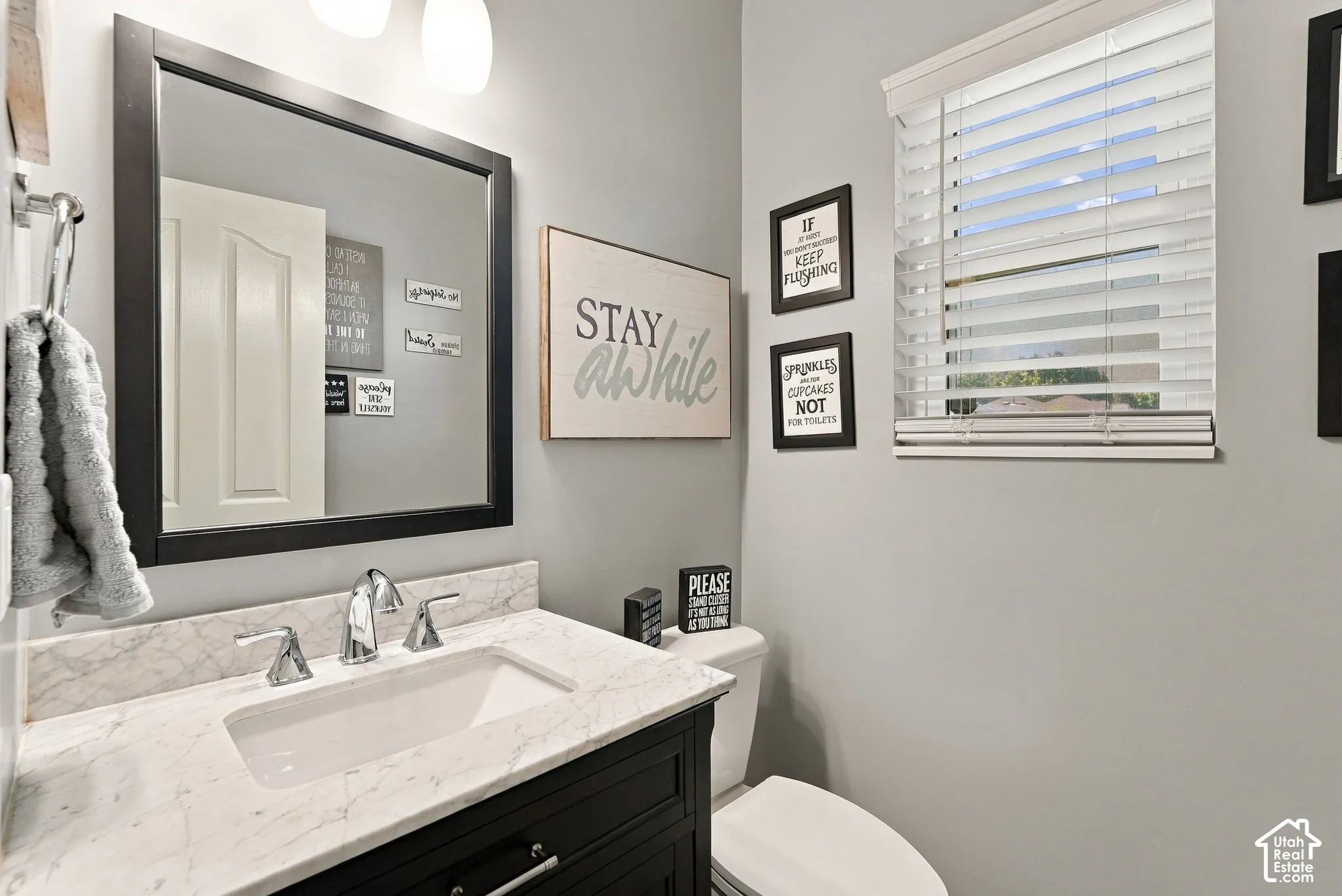 Single vanity with a white rectangular sink, chrome faucet, and stone countertop