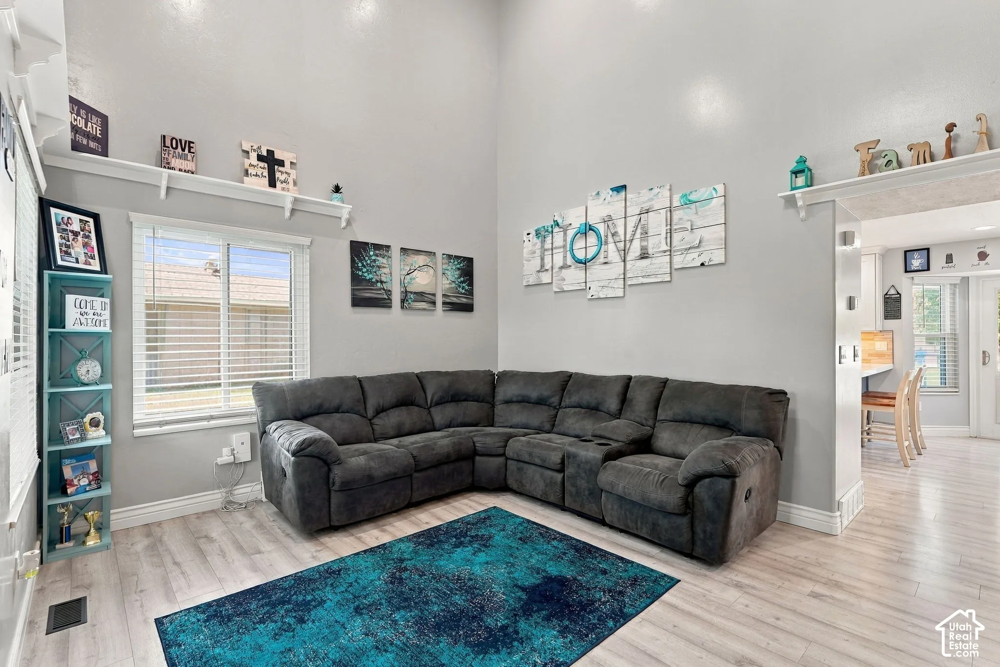 Vaulted ceilings, wood-finish flooring, and a large window with blinds