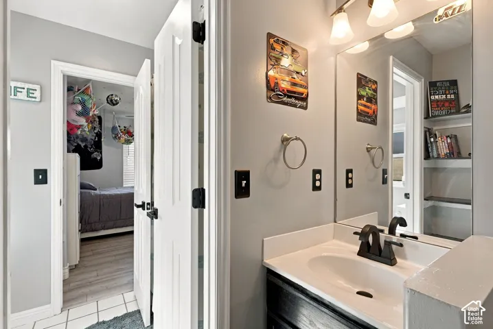 Vanity with a white countertop and integrated sink, black faucet, and rectangular mirror