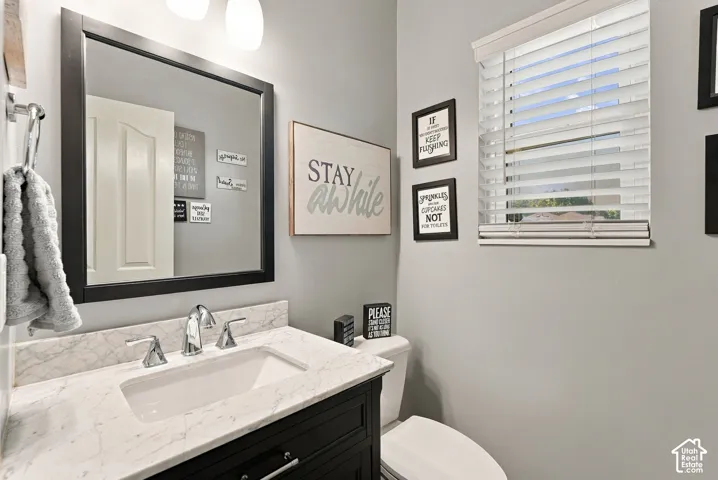 Single vanity with a white rectangular sink, chrome faucet, and stone countertop