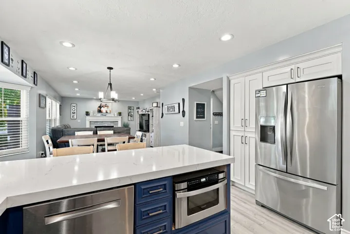 Kitchen island with a light-toned countertop, built-in microwave, and blue cabinetry