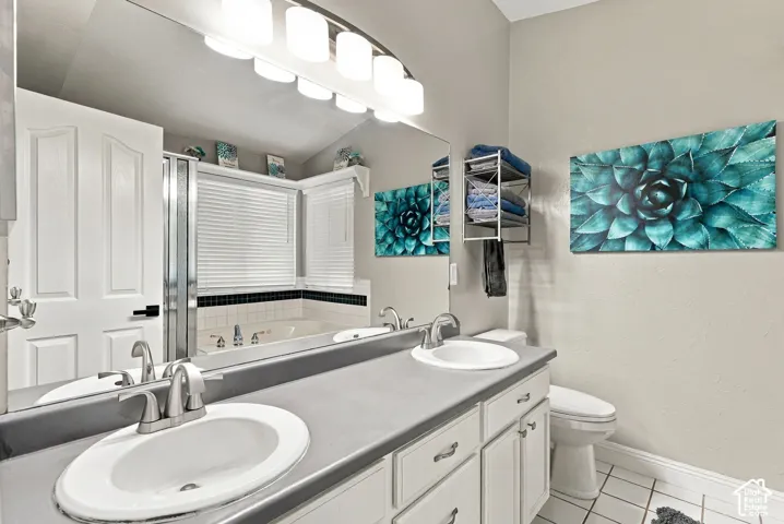 Dual vanity with brushed nickel faucets, white cabinetry, and a neutral countertop