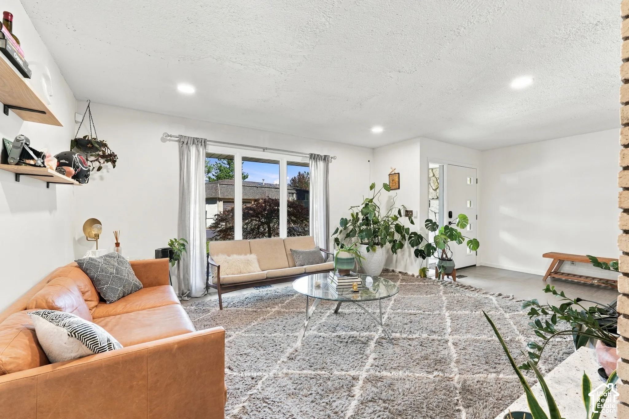 Recessed ceiling lighting, white painted walls, large window with multi-pane design, and a white front entry door with vertical glass inserts