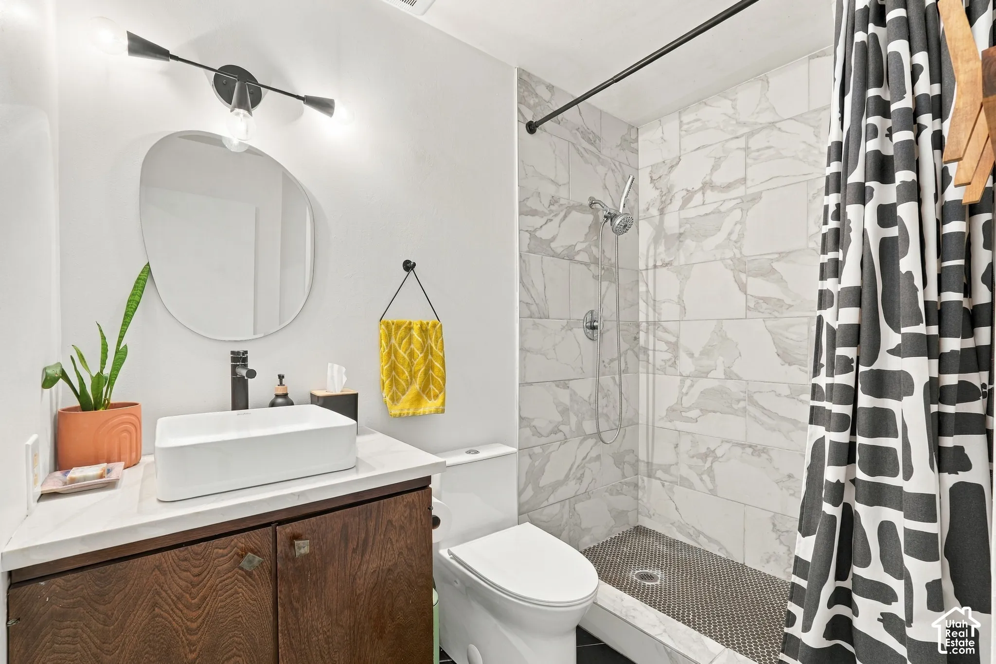 Vanity with a rectangular vessel sink, dark wood-finish cabinetry, and a modern wall-mounted light fixture