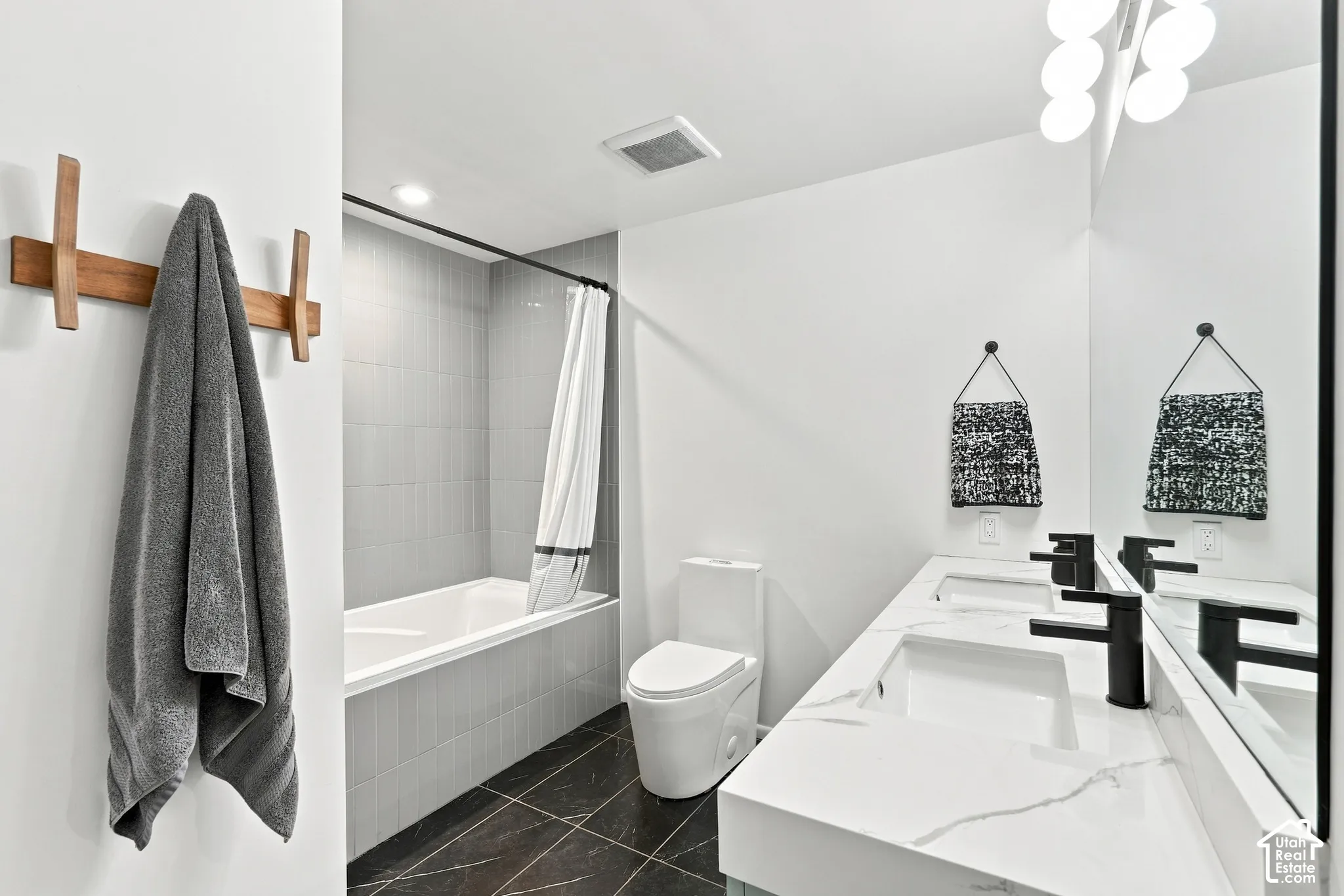 Dual vanity with integrated rectangular sinks, black matte faucets, and a large wall-mounted mirror
