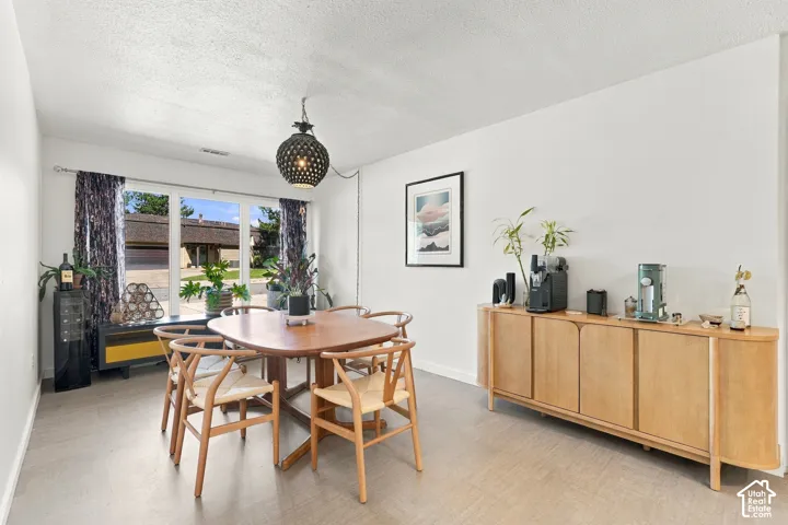 Recessed lighting, large window, wood-finish flooring, white walls, and a decorative pendant light