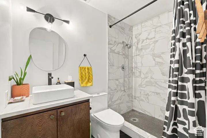 Vanity with a rectangular vessel sink, dark wood-finish cabinetry, and a modern wall-mounted light fixture