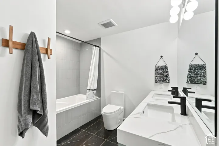Dual vanity with integrated rectangular sinks, black matte faucets, and a large wall-mounted mirror