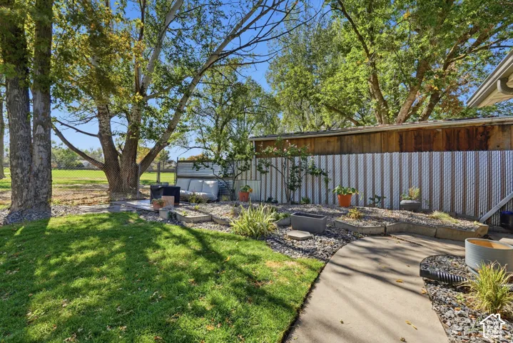 Expansive grassy lawn, mature trees, and a concrete pathway