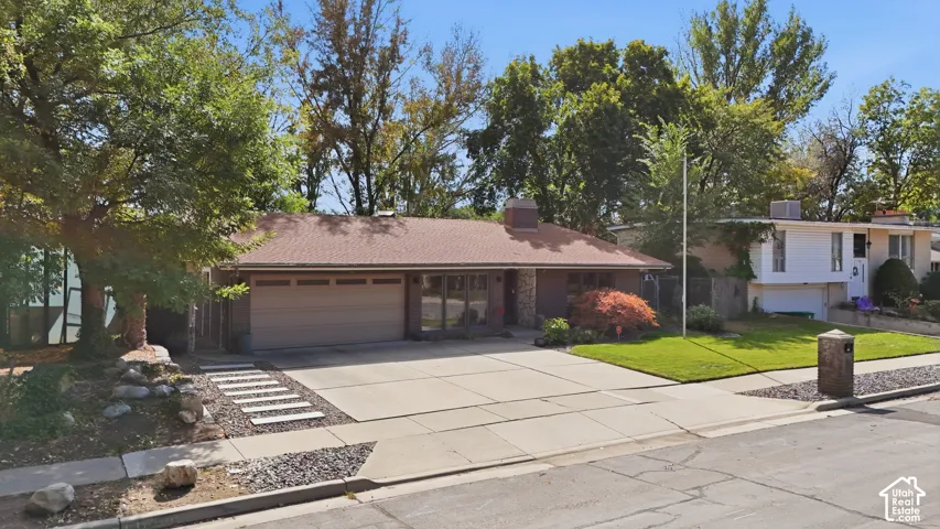 Single-story residence featuring a two-car garage, concrete driveway, and a shingled roof