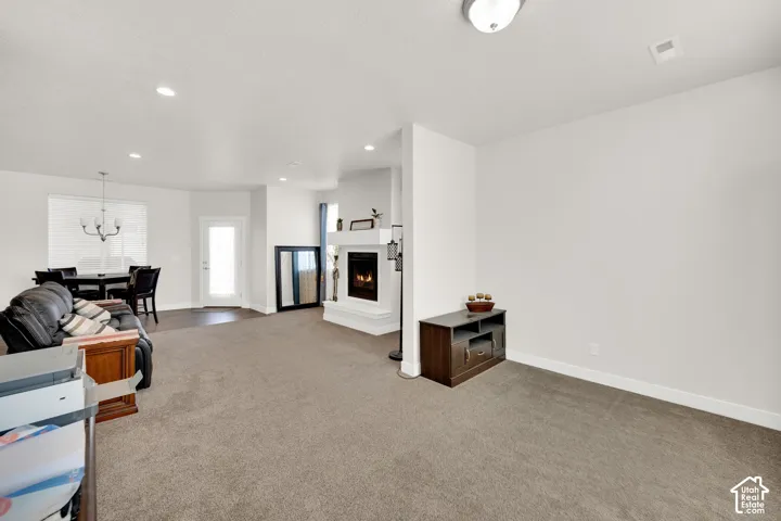 Living area with recessed lighting, fireplace, and carpet flooring