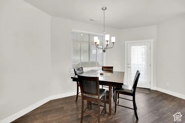 Wood-finish flooring, white walls, built-in window blinds, and a frosted glass door with white trim