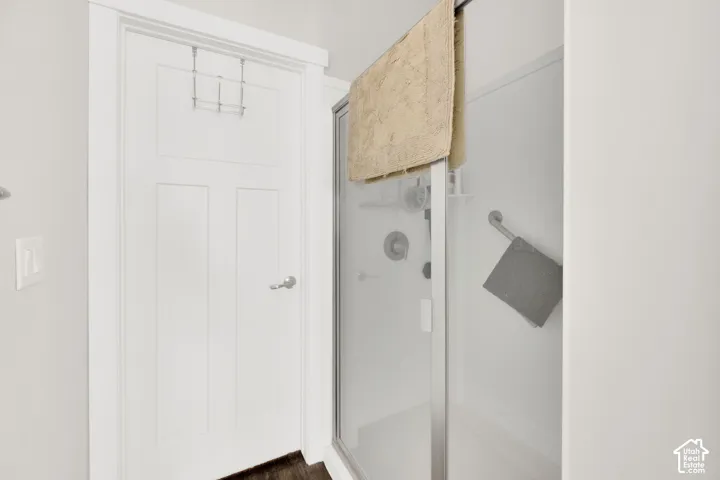 Shower enclosure with clear glass door, white shower surround, and integrated shower controls