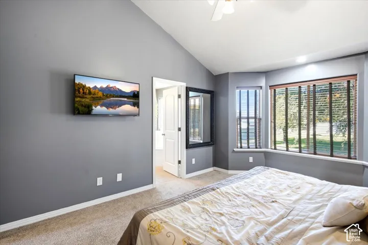 Vaulted ceiling, carpet flooring, bay window with blinds, recessed lighting, and a ceiling fan