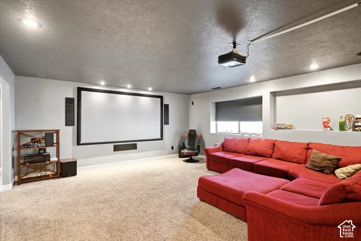 Large projection screen, recessed ceiling lighting, built-in shelving, mounted ceiling projector, and wall-mounted speakers
