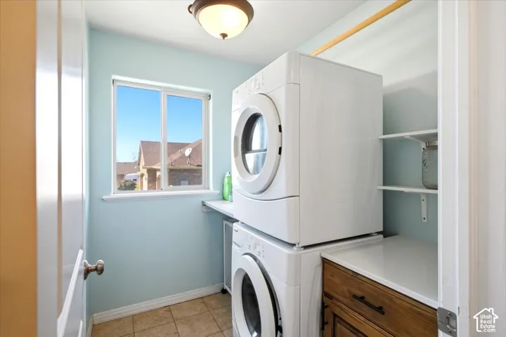 Window with natural light, tiled flooring, integrated shelving, and wood-finish cabinetry