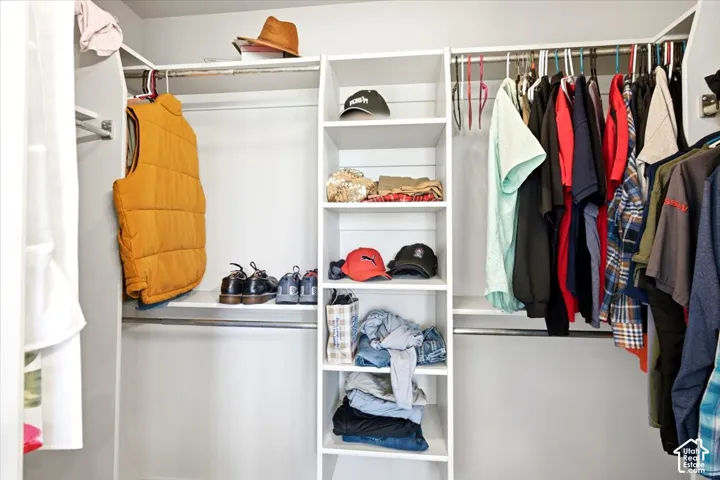 Built-in white shelving system with hanging rods and multiple storage compartments