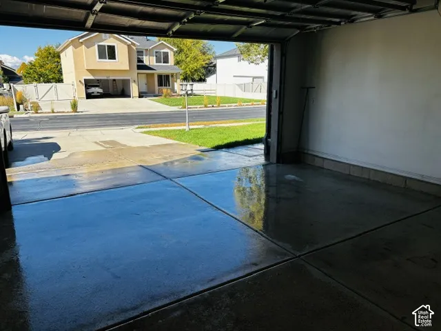 Attached garage featuring a concrete floor and white painted walls